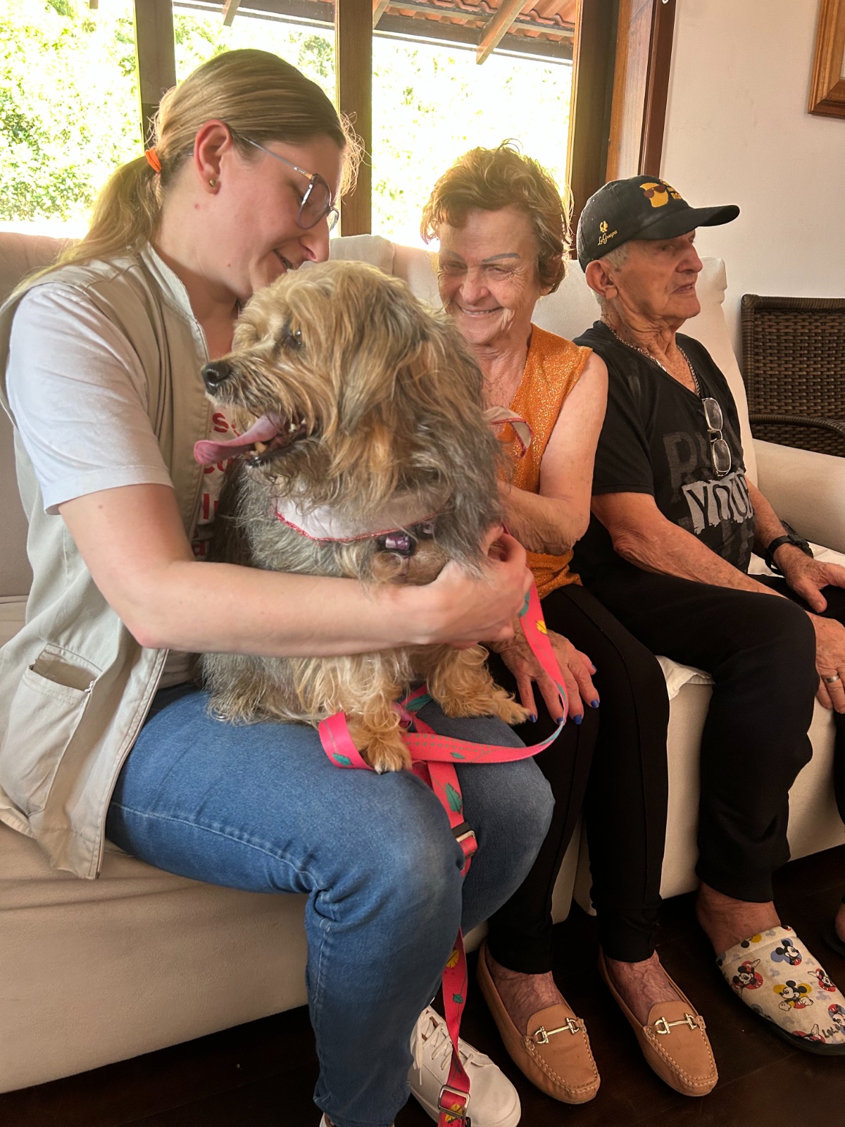 Trapapets segurando um cachorro visitam asilo